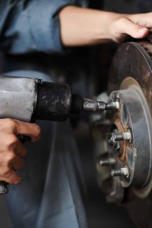 Mechanic Changing Car Tyre Hands of mechanic changing car tyre for client